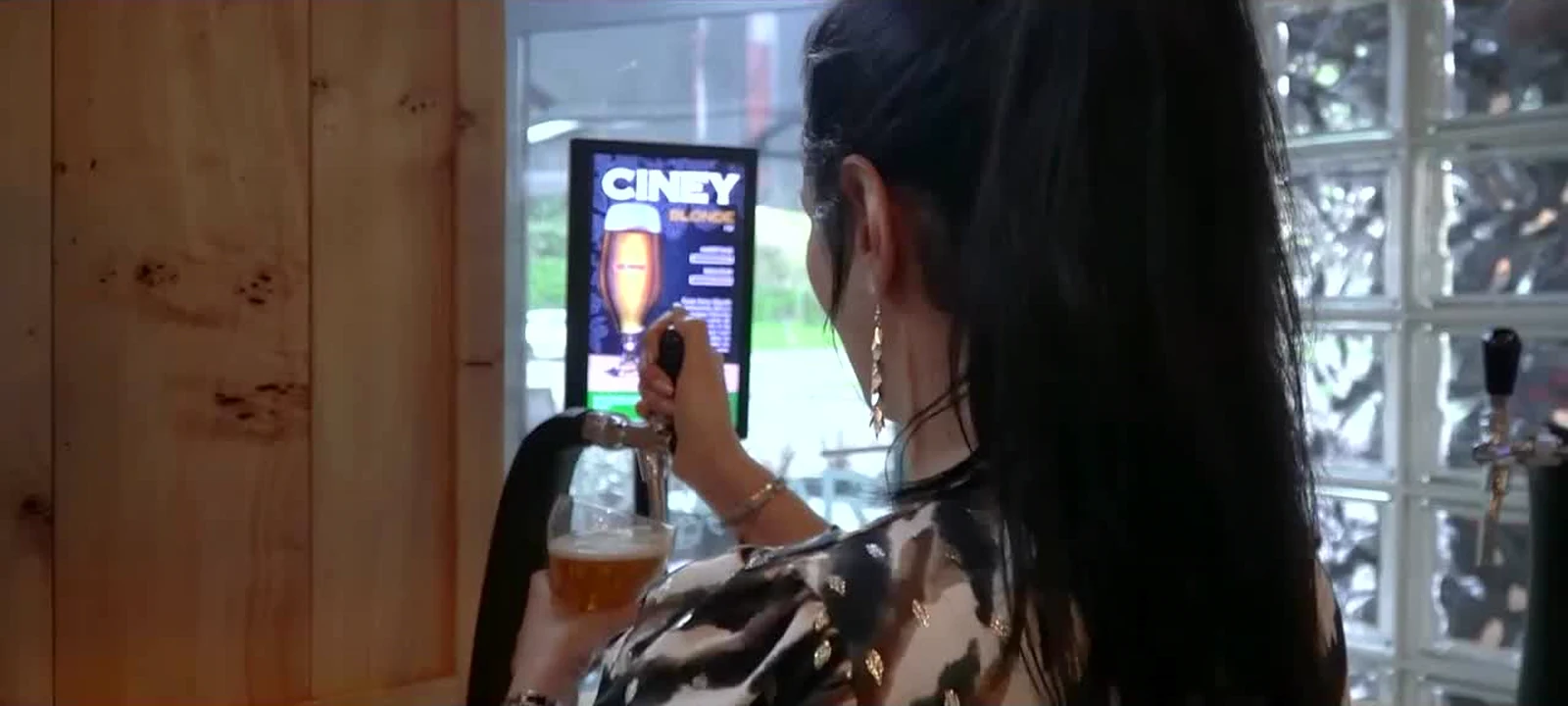 Une cliente se sert à la tireuse pendant le pilote réel Hop’n Bar de 2021-2022, sur la génération précédente.